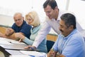 Teacher assisting mature student in class Royalty Free Stock Photo