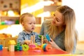 Teacher and baby one year ago playing logical toys in nursery Royalty Free Stock Photo