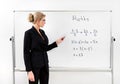 A teacher in a black suit near a whiteboard in a modern classroom teaches math. Copy space Royalty Free Stock Photo