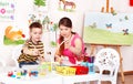 Teacher and boy learn draw in play room.