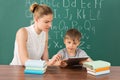 Teacher With Boy Using Digital Tablet In Classroom Royalty Free Stock Photo