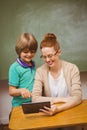 Teacher and boy using digital tablet in classroom Royalty Free Stock Photo
