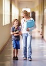 Teacher, child and walking in corridor at school, talking and bonding together. Education, smile and woman walk with kid Royalty Free Stock Photo