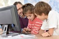 Teacher with children at computing class Royalty Free Stock Photo