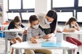 Teacher and children with face mask back at school after covid-19 quarantine and lockdown. Royalty Free Stock Photo