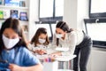 Teacher and children with face mask back at school after covid-19 quarantine and lockdown. Royalty Free Stock Photo