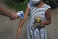 Teacher, children with face mask at school after covid-19 quarantine and lockdown. temperature check in school kid girl at school Royalty Free Stock Photo