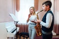 Teacher claps instead of a metronome for a student on saxophone in music lesson that focuses on playing