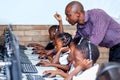 Teacher in classroom showing kids computer skills.