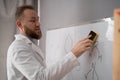 Teacher cleaning the whiteboard holding eraser erasing in classroom Royalty Free Stock Photo