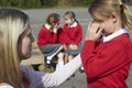 Teacher Comforting Victim Of Bullying In Playground Royalty Free Stock Photo