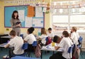 Teacher with computer in front of primary school class Royalty Free Stock Photo