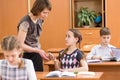 Teacher confiscating mobile phone at lesson in school