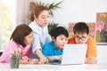 Teacher and Cute Asian children using laptop computer together. Royalty Free Stock Photo
