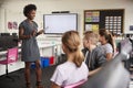 Teacher With Digital Tablet Talking To Line Of High School Students Sitting By Screens In Computer Class Royalty Free Stock Photo