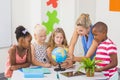 Teacher discussing globe with kids Royalty Free Stock Photo