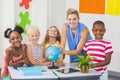 Teacher discussing globe with kids Royalty Free Stock Photo