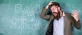 Teacher or educator stands near chalkboard with inscription back to school. Hate school. Teacher unhappy shouting Royalty Free Stock Photo