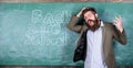 Teacher or educator stands near chalkboard with inscription back to school. Teacher unhappy shouting hysterically face Royalty Free Stock Photo