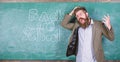 Teacher or educator stands near chalkboard with inscription back to school. Teacher unhappy shouting hysterically face Royalty Free Stock Photo