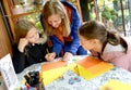 A teacher is engaged with children drawing on colored paper. Outdoor Children `s Master Class