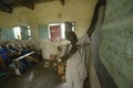 Teacher of English syllables to children in blue uniforms at school behind desk near Tsavo National Park, Kenya, Africa