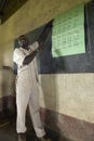 Teacher of English syllables to children in blue uniforms at school behind desk near Tsavo National Park, Kenya, Africa Royalty Free Stock Photo