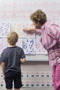 Teacher Explaining Calendar To Little Boy Royalty Free Stock Photo