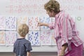 Teacher Explaining Calendar To Little Boy Royalty Free Stock Photo