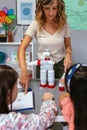 Teacher explaining to children how make recycled toy robot with plastic packages