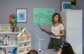 Teacher explaining types of renewable energies in poster at ecology classroom Royalty Free Stock Photo