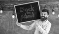 Teacher in eyeglasses holds blackboard with title back to school. Hiring teachers concept. Man with beard and mustache