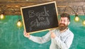 Teacher in eyeglasses holds blackboard with title back to school. Hiring teachers concept. Man with beard and mustache