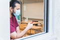 Teacher with a face mask checks his schedule on his smartphone in an empty classroom