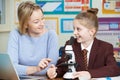 Teacher With Female Student Using Microscope In Science Class Royalty Free Stock Photo