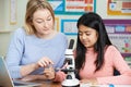 Teacher With Female Student Using Microscope In Science Class Royalty Free Stock Photo