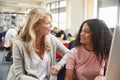 Teacher And Female Student Work On Computer In College Library