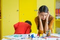 Teacher get headache with two naughty kids in classroom at kindergarten school.