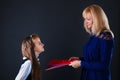 The teacher gives the girl student folders with teaching material