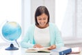 Teacher with globe and book at school