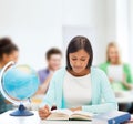 Teacher with globe and book at school