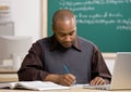 Teacher grading papers in school classroom Royalty Free Stock Photo
