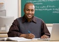 Teacher grading papers in school classroom Royalty Free Stock Photo