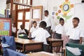 Teacher greets kids arriving at elementary school classroom Royalty Free Stock Photo