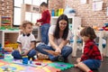 Teacher with group of boys sitting on floor having lesson at kindergarten Royalty Free Stock Photo