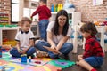 Teacher with group of boys sitting on floor having lesson at kindergarten Royalty Free Stock Photo