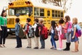 Teacher and a group of elementary school kids at a bus stop Royalty Free Stock Photo