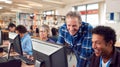 Teacher With Group Of Mature Adult Students In Class Working At Computers In College Library Royalty Free Stock Photo