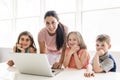 Teacher with a group of school children with laptop on the front