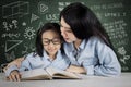 Teacher guides her student to read a book Royalty Free Stock Photo